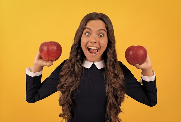 Vita sana dieta e bellezza per bambini cura dentale pausa pranzo stupito ragazza adolescente con frutta mela rossa