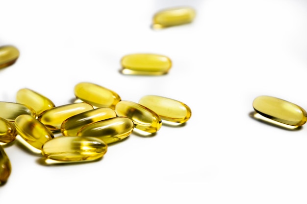 Vitamine in capsule olio di pesce omega 3 e vitamina D su sfondo bianco