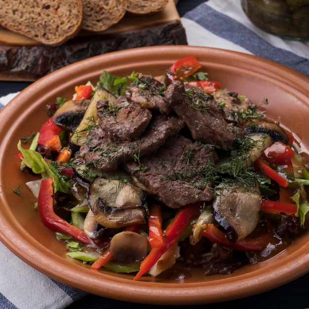 Vitello alla griglia guarnito con verdure Insalata di carne saporita con verdure Primo piano