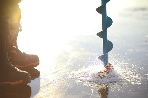 Viti da ghiaccio con piccozza sulla pesca invernale nelle grotte di ghiaccio Il ghiaccio è molto pulito e bello Il lago Baikal