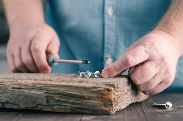 Viti su legno in mani maschili