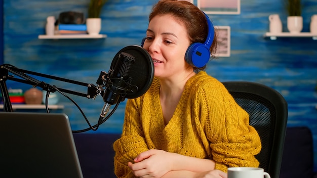 Vlogger donna che registra sul tutorial della fotocamera sullo stile di vita nello studio podcast di casa durante il livestreaming