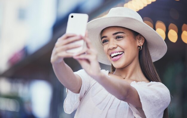 Vlogger donna e social media con sorriso in città per viaggi selfie o foto profilo e ricordi Felice influencer femminile sorridente per viaggi vlog o connessione 5G online in una città urbana