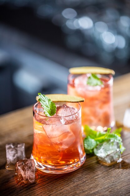 Vodka e mirtillo rosso in due bicchieri su un bar.