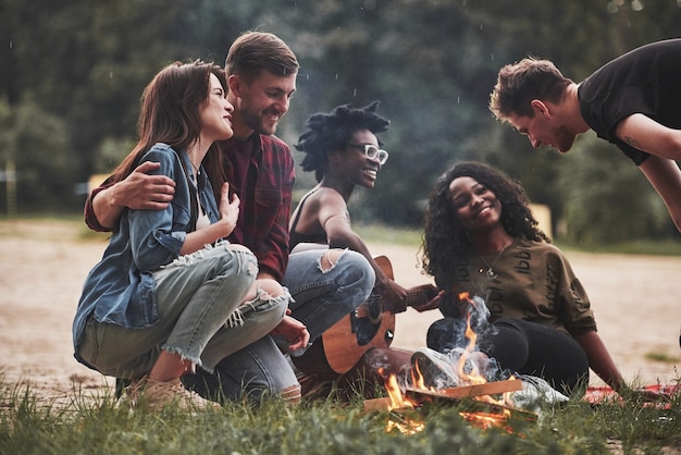 Voglio dirti una cosa. Un gruppo di persone fa un picnic sulla spiaggia. Gli amici si divertono durante il fine settimana.