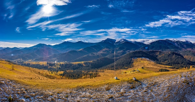 Volando sopra la torre delle comunicazioni, paesaggio invernale innevato di montagna.