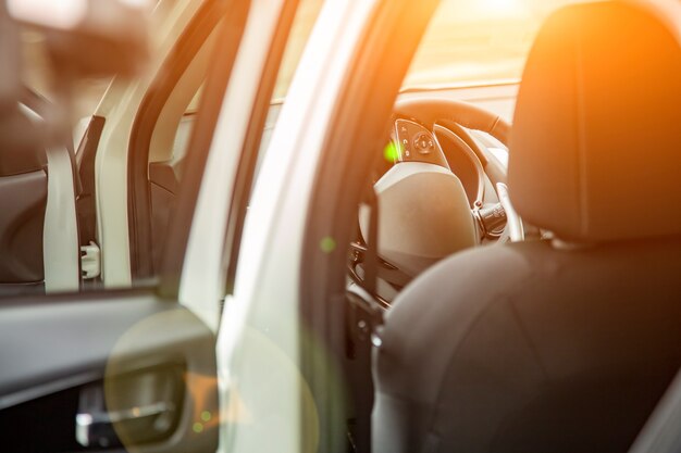 Volante e sedile del conducente vuoto della nuova auto suv premium visto dalla porta posteriore. messa a fuoco selettiva. sedile del conducente al sole