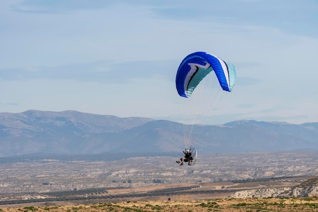 Volare con il paramotore in aria su sfondo blu cielo