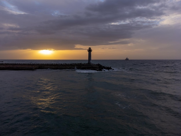 Volare intorno al faro su un drone la mattina presto all'alba