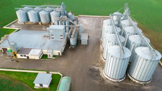Volo con drone su un grande complesso agroindustriale e barili di silos per cereali presso l'impianto di produzione agricola per la lavorazione, l'essiccazione, la pulizia e lo stoccaggio di prodotti agricoli, farina, cereali