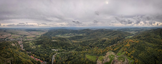 Volo del drone sopra le montagne ricoperte di foresta nella stagione autunnale vista aerea del villaggio di montagna beauti