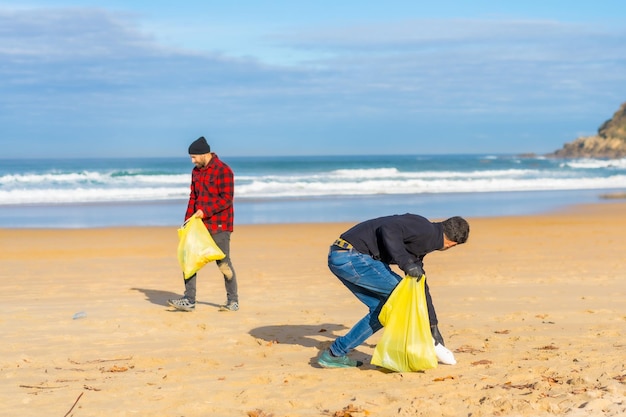 Volontari che raccolgono plastica sulla spiaggia Concetto di ecologia inquinamento del mare