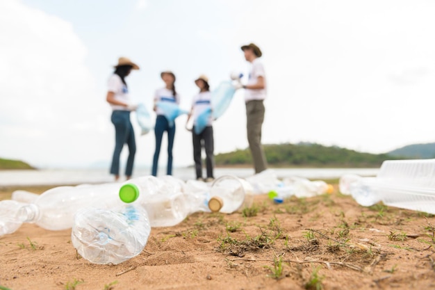 Volontari della comunità giovanile asiatica che usano i sacchi della spazzatura per ripulire la natura par