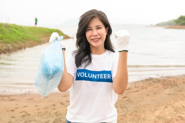 Volontari della comunità giovanile asiatica che usano i sacchi della spazzatura per ripulire la natura par