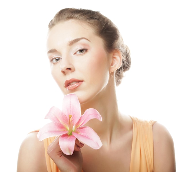 Volto della bellezza della giovane donna con giglio rosa