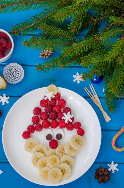 Volto di Babbo Natale fatto di lamponi e banana con cioccolato