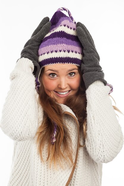 Volto di donna graziosa con guanti e berretto invernale a maglia con sorriso