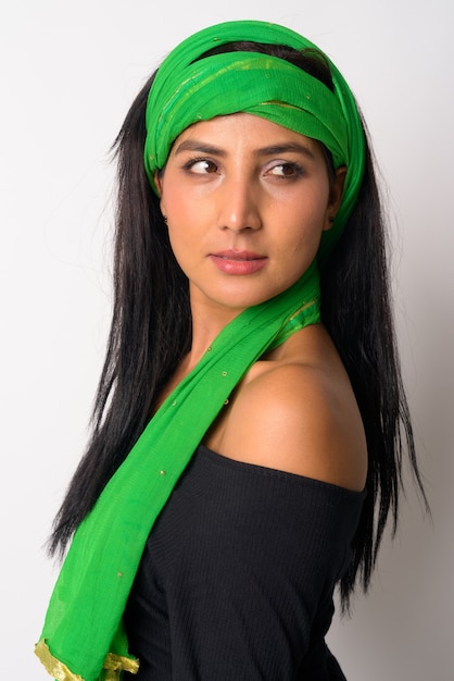 Volto di giovane bella donna persiana con sciarpa per la testa guardando sopra la spalla