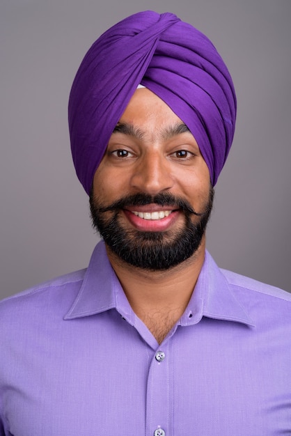 Volto di uomo d'affari indiano Sikh che indossa turbante e sorridente