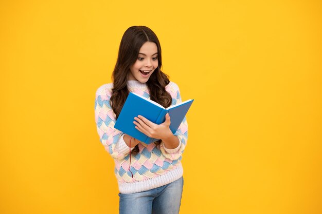 Volto eccitato La pupilla della ragazza teenager tiene i quaderni dei libri isolati su sfondo giallo spazio di copia Indietro