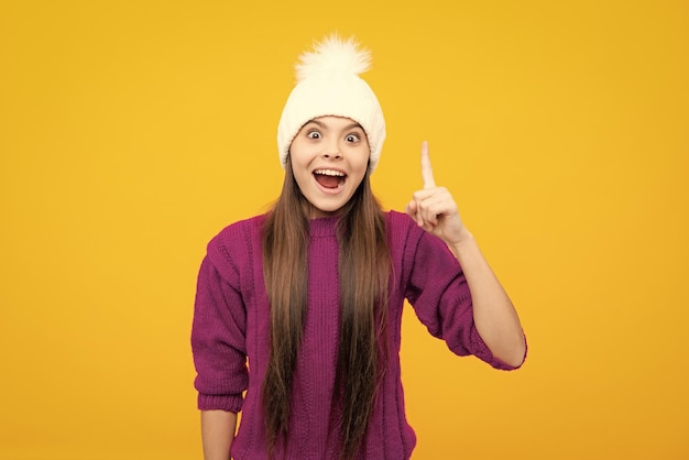 Volto eccitato Ragazza della scuola in abiti invernali e cappello caldo Vacanze invernali Modello di moda per bambini Espressione stupita allegra e felice