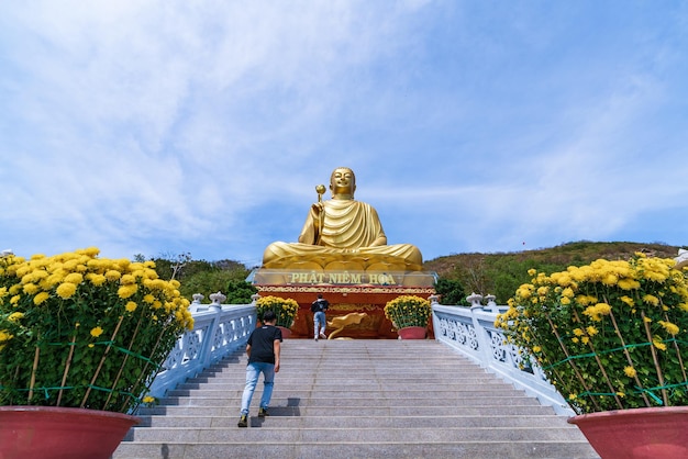 Vung Tau VIETNAM 12 febbraio 2023 La bella mattinata al Buddha d'oro con in mano un fiore di loto