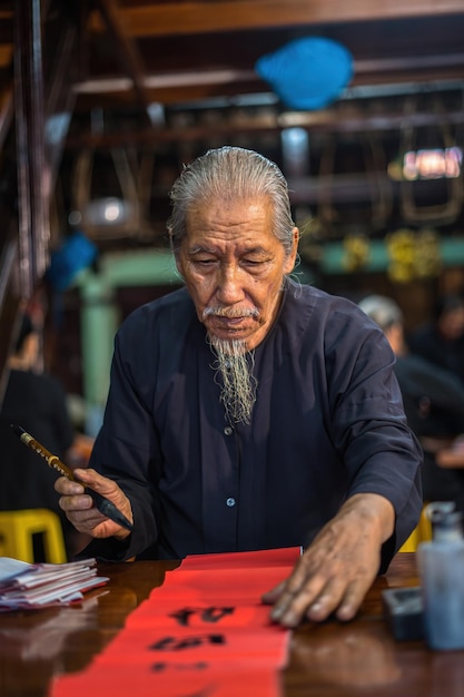 Vung Tau Vietnam 12 GENNAIO 2023 Lo studioso vietnamita scrive calligrafia al Long Son Il festival della calligrafia è una tradizione popolare durante le vacanze di Tet Scrivere distici per il Festival di Primavera del nuovo anno