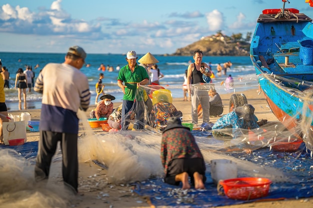 Vung Tau VIETNAM 14 MAGGIO 2023 Pescatore che getta la rete all'alba o al tramonto I pescatori tradizionali preparano la rete da pesca