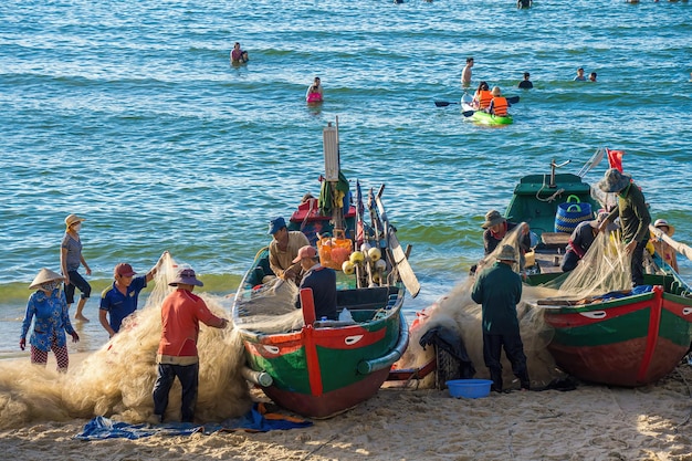 Vung Tau VIETNAM 20 AGOSTO 2022 Pescatore che getta la sua rete all'alba o al tramonto I pescatori tradizionali preparano la rete da pesca I pescatori sulla spiaggia alla pesca