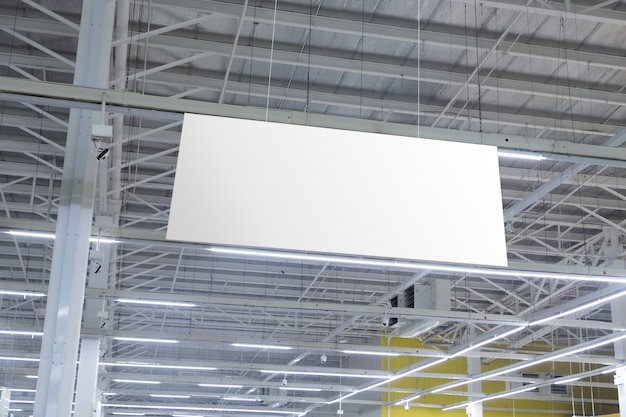 Vuoto bianco supermercato banner che pendono dal soffitto. Mockup di appendini pronto per il marchio o la pubblicità