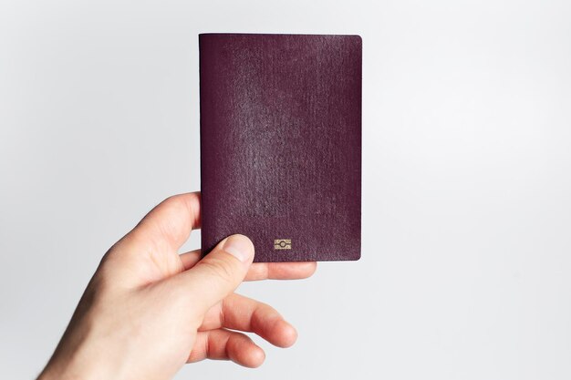 Vuoto del passaporto rosso con chip in mano maschile isolato su sfondo bianco Vista del primo piano