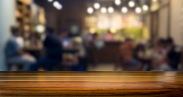 Vuoto tavolo di legno per il prodotto presente sul negozio di caffè o soft drink sfocatura sfondo bar con immagine bokeh.