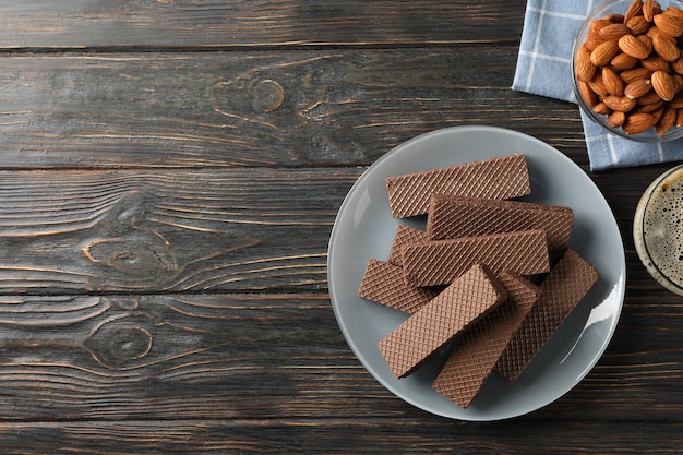 Wafer, tazza di caffè e mandorla su fondo di legno, vista dall'alto