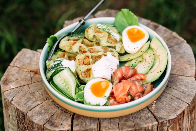 Waffle belgi con avocado salmone e uovo in un piatto