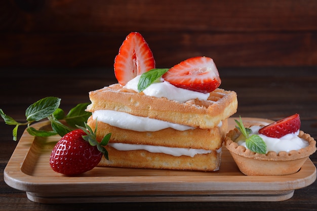 Waffle belgi con fragole, panna montata e foglie di menta