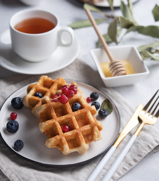 Waffle belgi con frutti di bosco, miele e tè