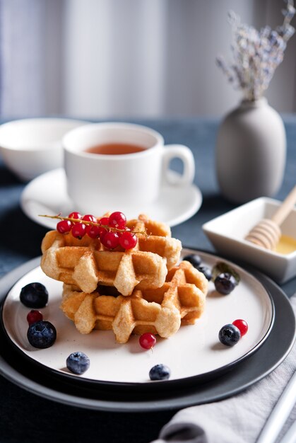 Waffle belgi con frutti di bosco, miele e tè