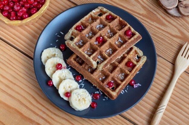 Waffle belgi con frutti di bosco (ribes rosso), banane e scaglie di cocco