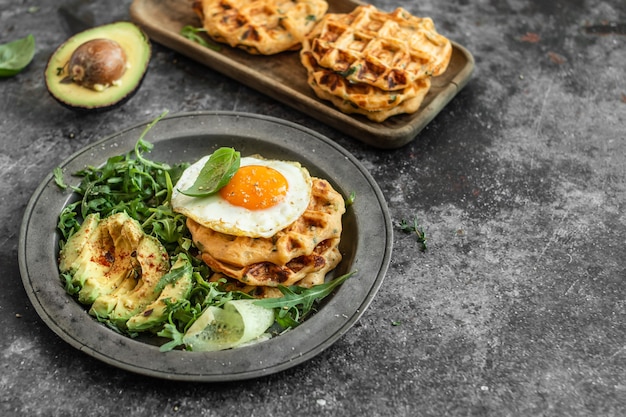 Waffle di patate con uovo fritto, avocado e rucola fresca