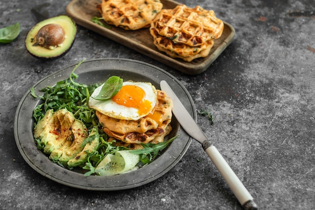 Waffle di patate con uovo fritto, avocado e rucola fresca