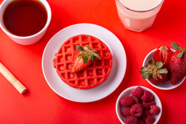 waffle rossi sani con frutta miele e latte su sfondo rosso con diverse angolazioni