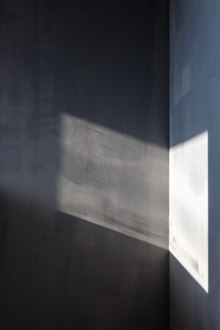 Walls painted in gray, sunlight falls on the walls through the window.