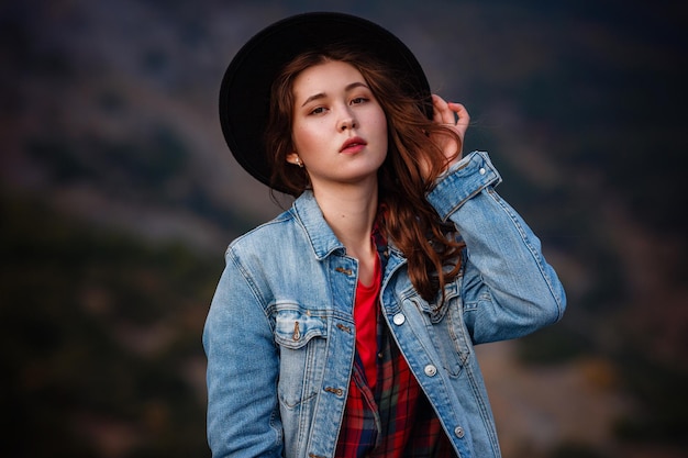 Wanderlust concetto elegante hipster ragazza con cappello con zaino a piedi in montagna donna bohémien viaggiatore esplorando alla luce del sole spazio per testo momento atmosferico