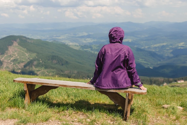 Wanderlust donna che fa una pausa dalle escursioni e guarda il bellissimo paesaggio naturale all'aperto sulla cima di una montagna Ragazza felice in piedi all'indietro guardando lontano Viaggiando in montagna