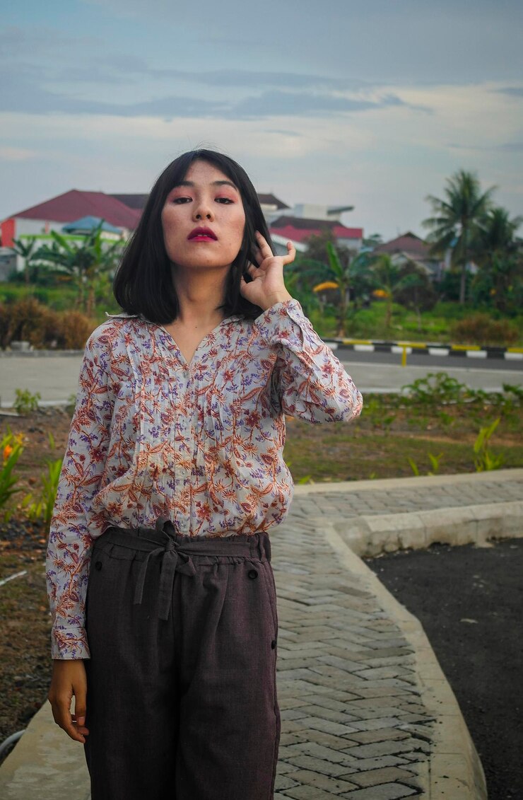 Photo wanita muda cantik berdiri di tanah dengan latar langit