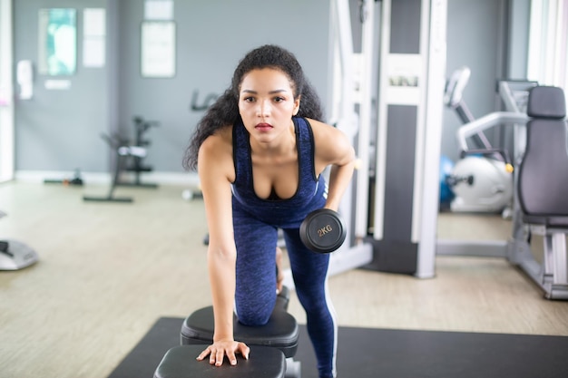 Wasit up immagine di una giovane donna afroamericana in forma che si allena con i pesi a mano in una palestra fitness