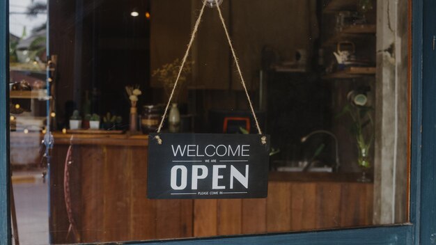 Welcome were open vintage black and white retro sign on a coffee glass door cafe after coronavirus lockdown quarantine Owner small business food and drink business reopen again concept