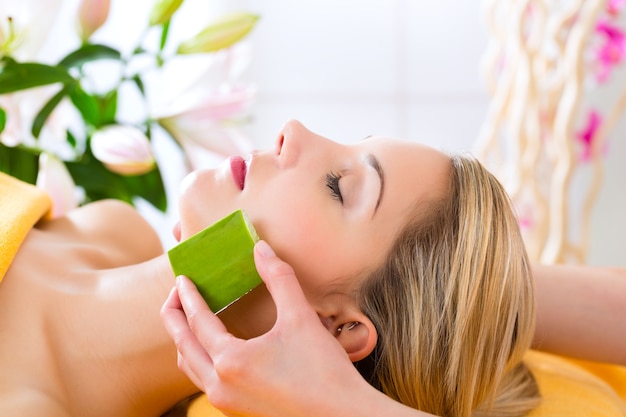 Wellness - donna che riceve massaggio alla testa o al viso con aloe vera nella spa