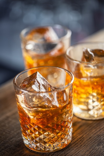 Whisky bourbon su ghiaccio servito in bicchieri decorativi.