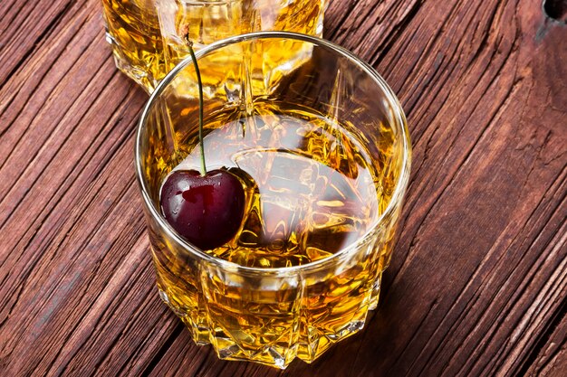 Whisky con ghiaccio e ciliegia in due bicchieri